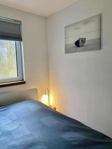 a bedroom with a bed and a picture on the wall at Ferienbungalow Arne am Wald in Woltersdorf