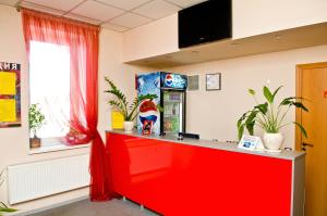 un mostrador rojo en una habitación con plantas y una ventana en Pit Stop, en Poddubki