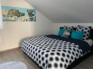 a bedroom with a black and white bed with blue pillows at Loft Bellevue in Saint-Louis