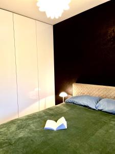 a bedroom with a bed with a book on it at Apartament z ogródkiem, blisko centrum in Zielona Góra