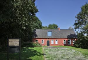 a red house with a sign in front of it at Sualma in Zwalm