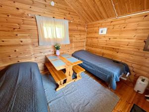 ein Schlafzimmer mit einem Bett und einem Tisch in einer Blockhütte in der Unterkunft Vuohimäki Camping Savonlinna in Savonlinna