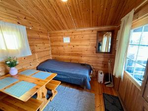 ein Schlafzimmer mit einem Bett in einem Holzzimmer in der Unterkunft Vuohimäki Camping Savonlinna in Savonlinna