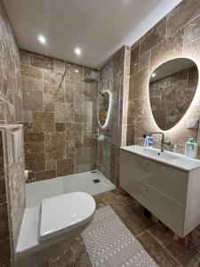 une salle de bains avec toilettes, lavabo et miroir dans l'établissement YOUSRA Appartement, à Poitiers