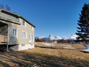 a house with snow covered mountains in the background at Arctic Cabin Lyngen in Svensby