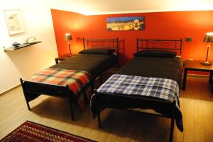two beds in a room with orange walls at Vintage Apartment in Caselle Torinese