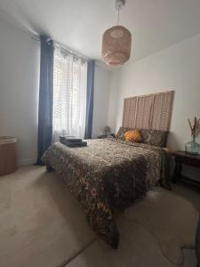 une chambre avec un lit avec une couette dessus dans l'établissement YOUSRA Appartement, à Poitiers