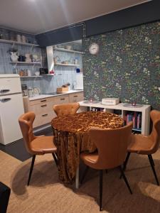a kitchen with a table and chairs and a refrigerator at Alice Apartment - main street in Rovaniemi +12 photos