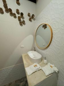 un baño con lavabo y espejo en Panorama garden inn, en Máncora