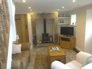 ein Wohnzimmer mit Couch und Kamin in der Unterkunft Quarry Cottage in Consett