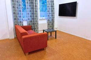 a living room with a red chair and a table at Lux Sports Camp in Kristinehamn