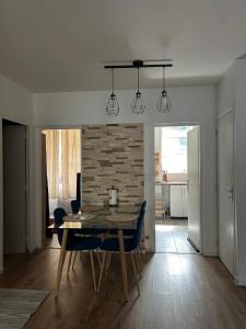 une table à manger avec des chaises et un mur en briques dans l'établissement YOUSRA Appartement, à Poitiers 4 autres photos