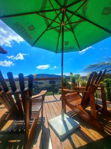 due sedie e un ombrellone verde su un ponte di Aconchego do Pôr do Sol Sebollas a Inconfidência Altre 10 foto