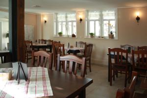 a dining room with tables and chairs and windows at Café im Hof- Bed & Breakfast in Streufdorf