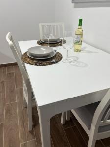 una mesa blanca con dos copas y una botella de vino en Casa Yaya, en Costa Calma