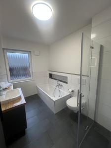 ein Badezimmer mit Badewanne, Toilette und Waschbecken in der Unterkunft Schöne Ferienwohnung in Buxtehude- Zentral -Lade Säule -6Person in Buxtehude