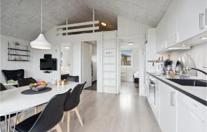 a kitchen and living room with a table and chairs at Two-Bedroom Holiday Home Ringkøbing 04 in Søndervig