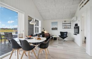 a dining room and living room with a table and chairs at Two-Bedroom Holiday Home Ringkøbing 04 in Søndervig