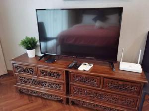 a television on top of a dresser with a bed at WOW Strait Quay Luxury Suite Room in Tanjong Tokong
