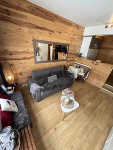 a living room with a couch and a table at Studio front de neige pelevos in Isola
