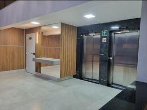 a hallway with three elevators in a building at Apartamento luxo no centro in Ubá