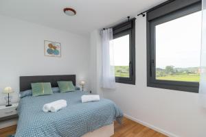 a bedroom with a bed with two towels on it at Suances mar y tierra con parking in Suances