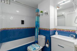 a blue and white bathroom with a toilet and a sink at Suances mar y tierra con parking in Suances