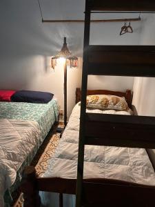 een slaapkamer met twee stapelbedden en een lamp bij Sitio Flor do Coriscão Paraty in Paraty