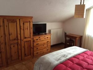 1 dormitorio con 1 cama y vestidor con TV en Hotel Sciatori en Sestriere