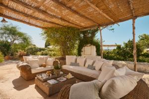 a living room with a couch and chairs under a pergola at The Guardian House in Santa Gertrudis de Fruitera