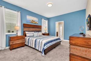 Schlafzimmer mit blauen Wänden, einem Bett und einer Kommode in der Unterkunft Luxury Champions gate 8Br Villa Champions Gate in Davenport + 37 Fotos