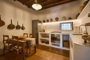 a kitchen with a table and a kitchen with pots and pans at The Guardian House in Santa Gertrudis de Fruitera