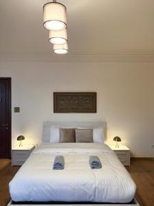 a bedroom with a large white bed with two lamps at Madliena Hills Mansion in Is-Swieqi +63 photos