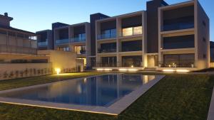 a building with a swimming pool in front of it at Marinhas Nature in Marinhas