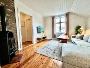 un soggiorno con un divano e una TV di Sentralt i Sarpsborg a Sarpsborg