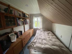 1 dormitorio con 1 cama en una habitación con estanterías en Norwegian house, en Hestnes