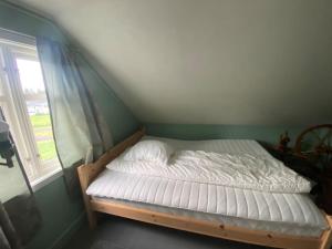 Cama en habitación verde con ventana en Norwegian house, en Hestnes