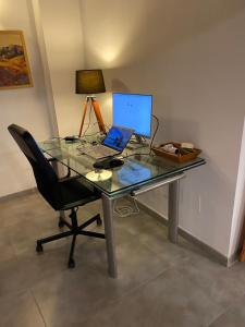 a glass desk with a laptop computer on top of it at Villa Maiteren Etxea- 4 Beds property with private pool in Playa Blanca +28 photos