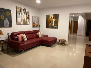 a living room with a red couch and some pictures at Villa Maiteren Etxea- 4 Beds property with private pool in Playa Blanca
