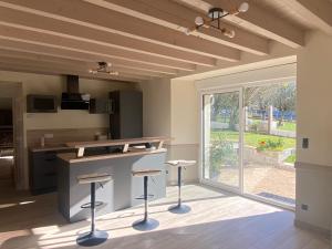 a kitchen with a counter and stools in a room at Gite familial en Valromey in Brénaz