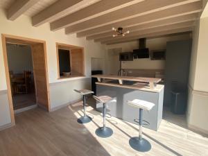 a kitchen with two stools and a counter in a room at Gite familial en Valromey in Brénaz +22 photos