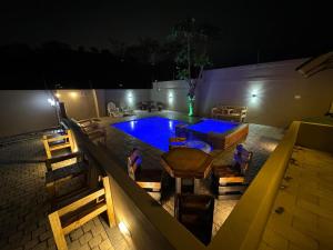 a swimming pool with a table and chairs and a blue pool at Durban Holiday Apartments by Mieli Estates , Unit 4 in Durban