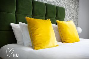 deux oreillers jaunes sur un lit avec une tête de lit verte dans l'établissement Boutique 1 Bdrm Duplex Suite on Marina-105, à Hull