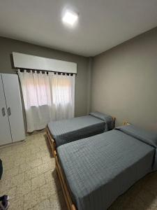 a bedroom with two beds and a window at EZEIZA 10 minutes the air port, barrio privado la celia quinta tauro in Ezeiza +6 photos