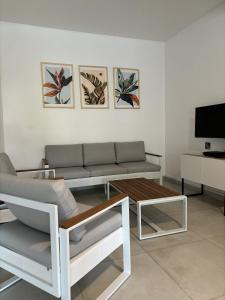a living room with a couch and a table at Les Terrasses de la Wallon Cannelle in Les Trois-Îlets