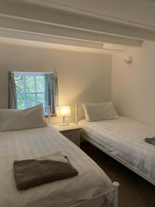 a bedroom with two beds and a lamp and a window at Stunning Rural Mill House nr beach and harbour in Banff