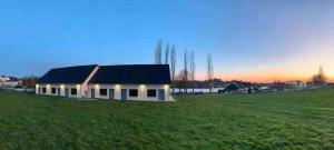 una piccola casa bianca in un campo con il tramonto di Appartement studio meublé a Bourbon-Lancy Altre 11 foto