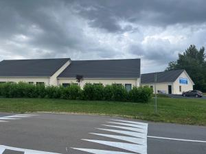 un edificio bianco con il tetto nero in un parcheggio di Appartement studio meublé a Bourbon-Lancy