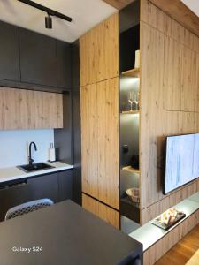 a kitchen with wooden cabinets and a counter top at Jahorina Apartman Dvosjed B 10 in Jahorina