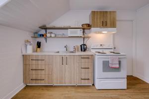 a kitchen with white appliances and wooden cabinets at Chambre 305 de l'hôtel Victoria confortable et moderne in Saint-Pascal